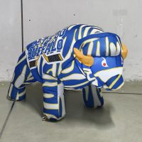 Blue, white and gold baby buffalo hockey inflatable lit up at night, front angle